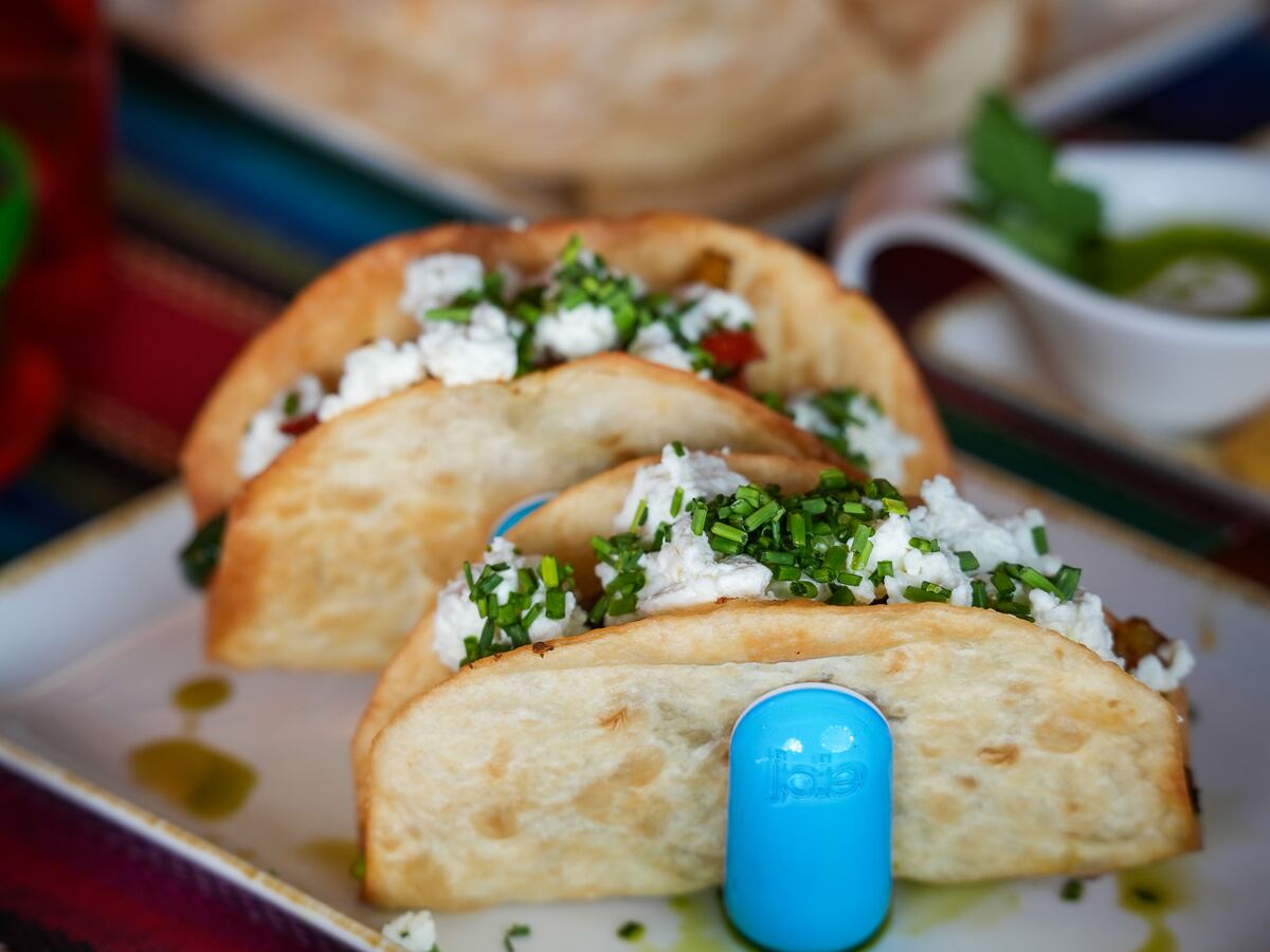 Stół zastawiony tacos, quesadillą i sosami