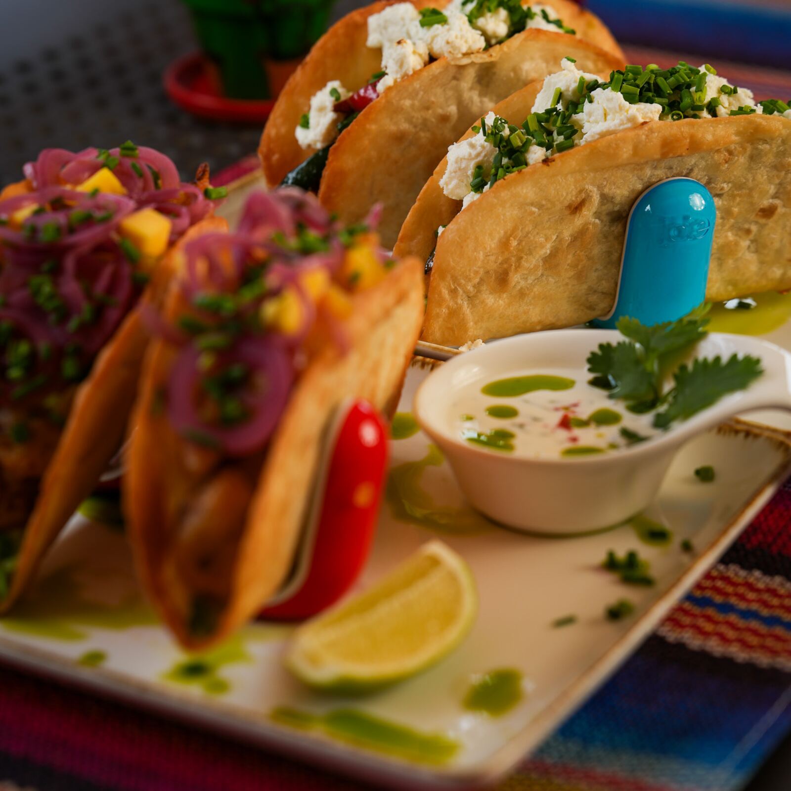Talerz tacos z salsą i limonką na kolorowym obrusie