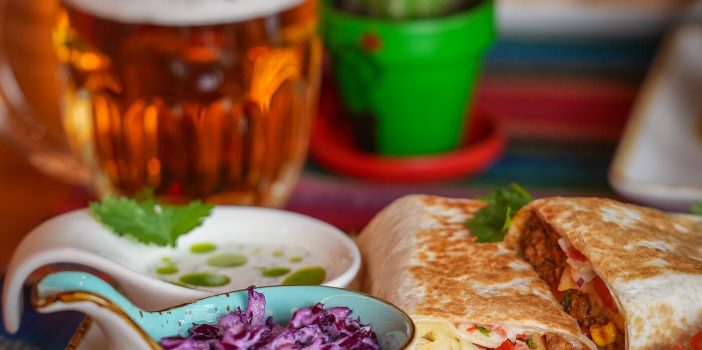 Burrito z sosem i coleslaw, w tle piwo lane